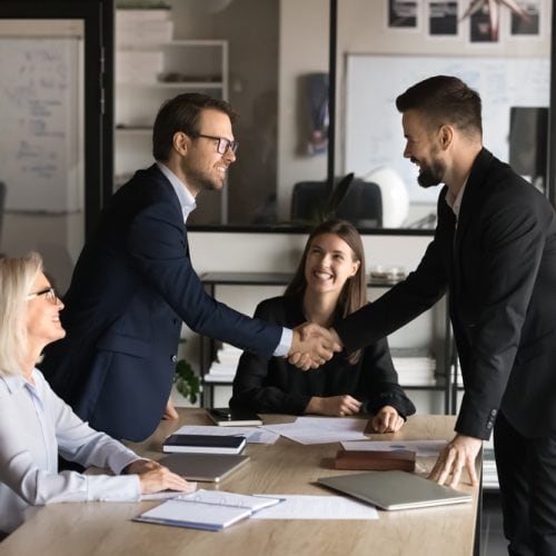 Two,Happy,Confident,Business,Partners,Men,Shaking,Hands,Over,Large