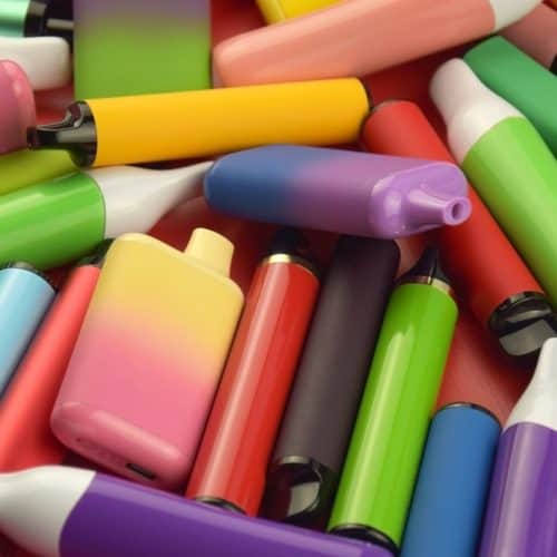 Set,Of,Multicolor,Disposable,Electronic,Cigarettes,On,A,Red,Background.