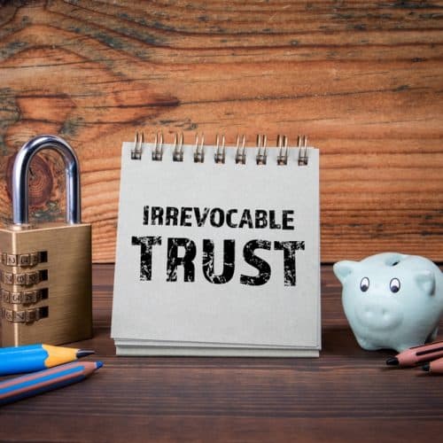 Irrevocable,Trust.,Cardboard,Notepad,On,Wooden,Texture,Table.