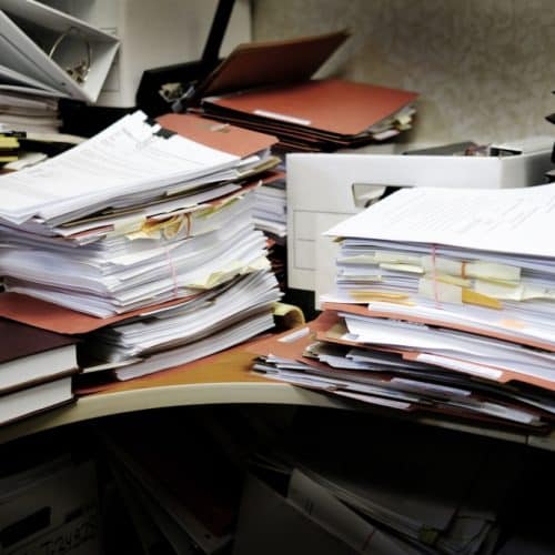Detail,Of,A,Messy,Desk,With,Books,Binders,Files,And
