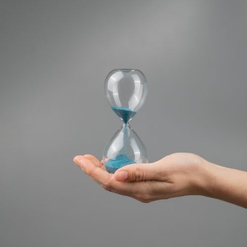 Woman,Holding,An,Hourglass,On,A,Gray,Background.,Close up.,Copy