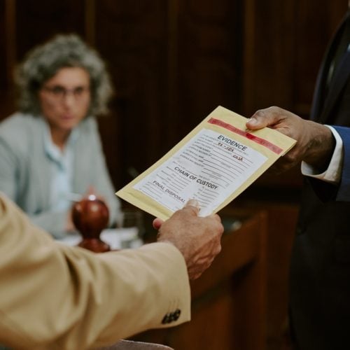 Middle,Aged,Caucasian,Man,Handing,Evidence,Envelope,To,Black,Man