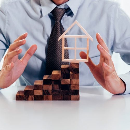 Close,Up,Of,Businessman,Using,Hand,To,Protect,Residential,House