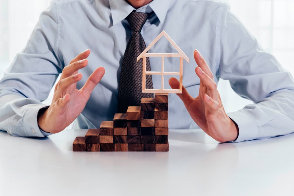 Close,Up,Of,Businessman,Using,Hand,To,Protect,Residential,House