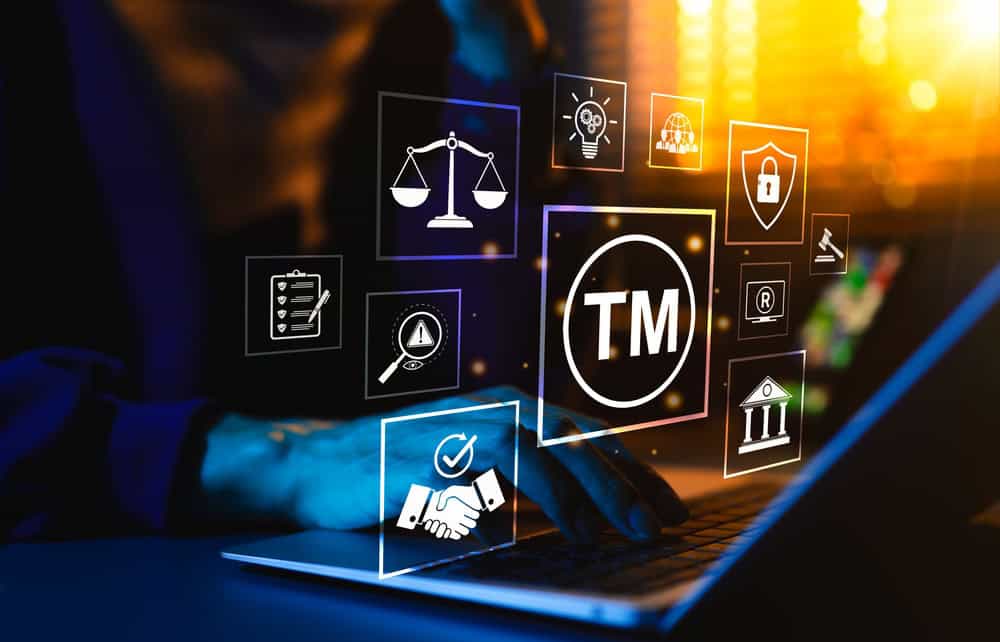 Trademark,Protection,Concept.,Person,Typing,On,Laptop,Surrounded,By,Icons