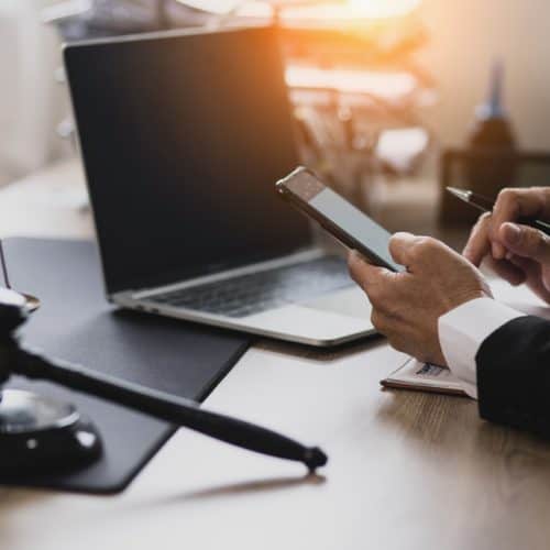 Lawyer,Hands,Working,With,Smartphone,And,Laptop,On,Table,Office,