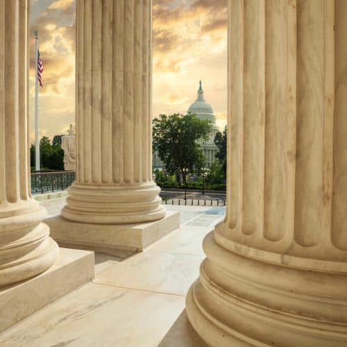 United,States,Capitol,Building,Viewed,Between,Columns,Of,The,Supreme