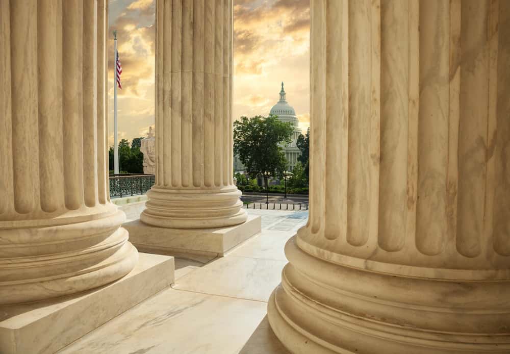 United,States,Capitol,Building,Viewed,Between,Columns,Of,The,Supreme
