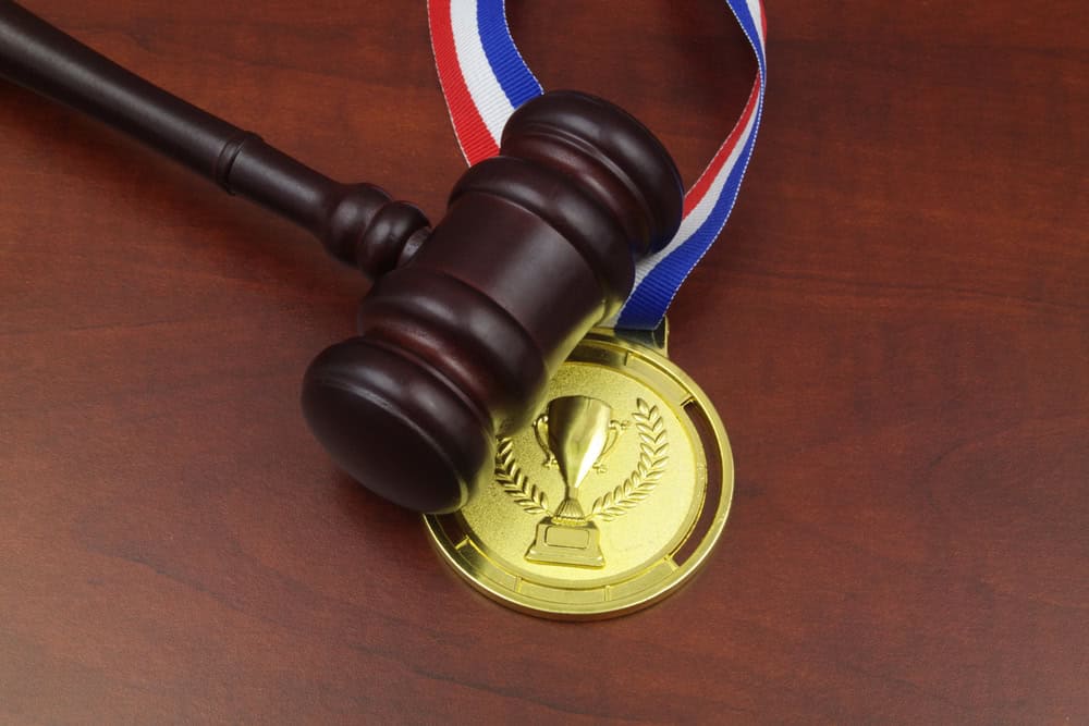 Wooden,Judge,Gavel,And,Gold,Medal,With,Trophy,Cup,Close