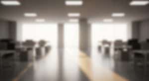 Blurred,Office,Space,Empty,Desks,With,Bright,Window,,And,Modern